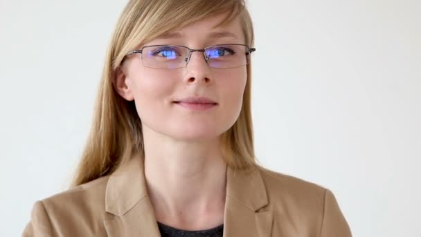 Retrato de una mujer de negocios feliz en gafas y una chaqueta de primer plano sobre un fondo blanco — Vídeo de stock