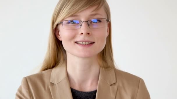 Retrato de una mujer de negocios feliz en gafas y una chaqueta de primer plano sobre un fondo blanco — Vídeos de Stock