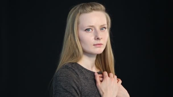 Emotional portrait of a blond girl on a black background — Stock Video