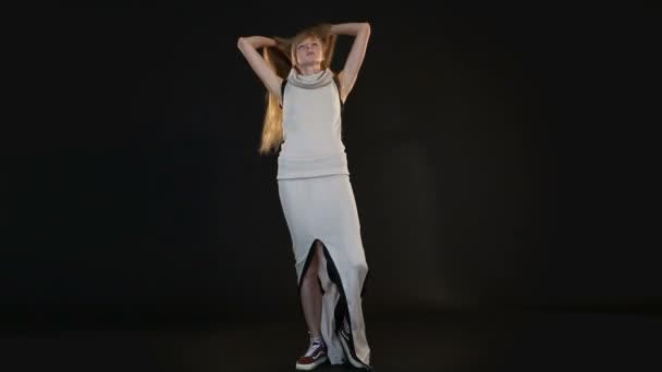 Блондинка модель європейської вигляд позує перед камерою в студії з чорним фоном — стокове відео
