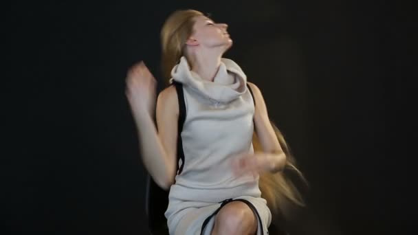 Blondes Model mit europäischem Aussehen posiert vor der Kamera im Studio auf schwarzem Hintergrund — Stockvideo