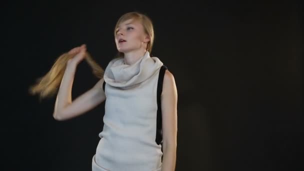 Блондинка модель європейської вигляд позує перед камерою в студії з чорним фоном — стокове відео