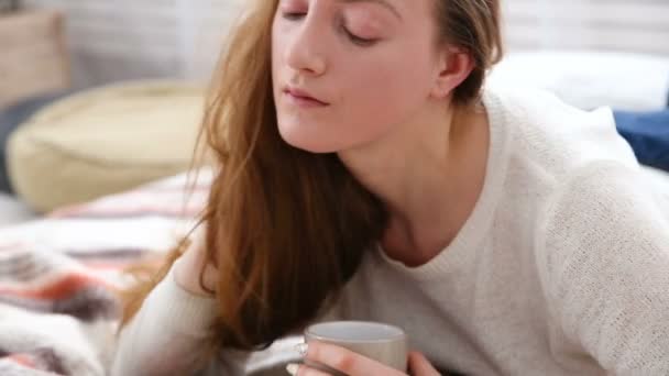 Kvinna dricker kaffe och läser bok i säng sovrum — Stockvideo