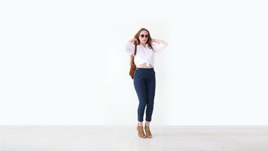 moda modern gençlik. şık kız kot pantolon, beyaz gömlek, deri sırt çantası ve gözlük ile beyaz duvara poz.