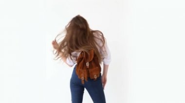 moda modern gençlik. şık kız kot pantolon, beyaz gömlek, deri sırt çantası ve gözlük ile beyaz duvara poz.