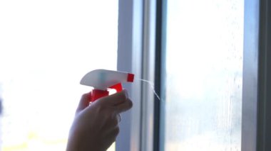 Pencereyi temizleyen genç kadın, ağır çekimde.