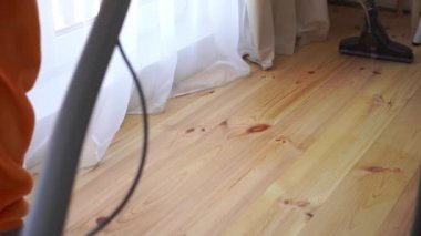 Elektrikli süpürgeyle ahşap zemini temizlemek, ağır çekim.
