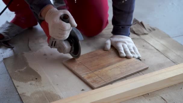 Réparation et décoration. un homme coupe des carreaux de céramique avec une meuleuse . — Video