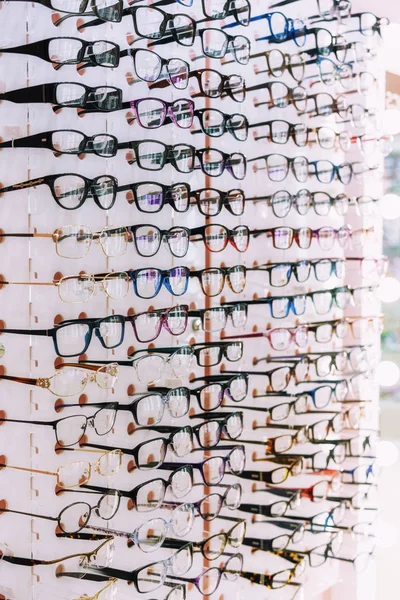 Uma grande variedade de óculos diferentes em uma prateleira em uma loja de óptica — Fotografia de Stock