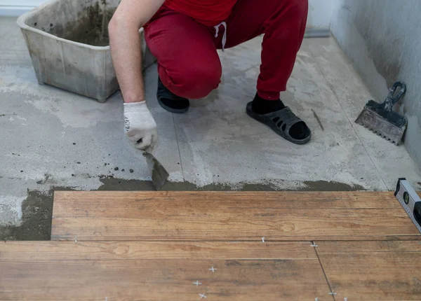 Reparatie en decoratie. de tegel zet de porseleinen tegels op de vloer in het appartement — Stockfoto