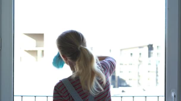 Mujer joven limpiando la ventana — Vídeos de Stock