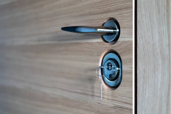Fechadura da porta com chave e alça de perto, bela porta de entrada de madeira moderna para o apartamento — Fotografia de Stock