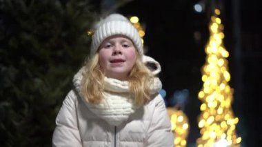 Güzel, yavaş çekim videosu. Sarışın bir kız kameraya kar fırlatıyor.