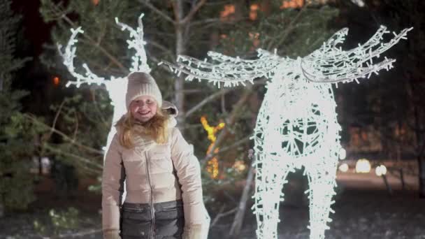 Beautiful portrait of a blonde laughing girl on a christmas decorated street in winter — Stockvideo