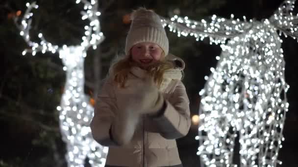 Beautiful slow motion video - a blonde girl throws snow at the camera — Stockvideo