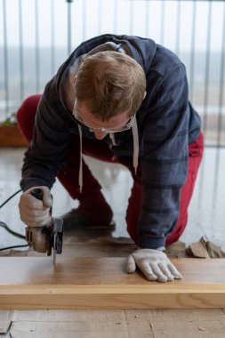 Tamir ve dekorasyon. Bir adam seramik fayansları öğütücüyle keser..