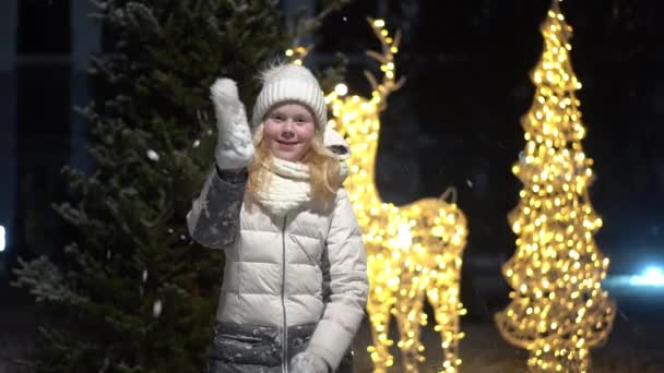 วิดีโอเคลื่อนไหวช้าที่สวยงาม สาวผมบลอนด์โยนหิมะที่กล้อง — วีดีโอสต็อก