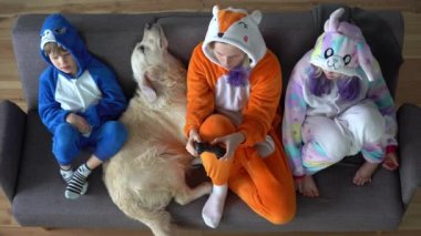 Kigurumi 'deki mutlu aile evdeki oturma odasındaki TV' de oyun konsolu oynuyor.