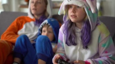 Kigurumi 'deki mutlu aile evdeki oturma odasında TV' de oyun konsolu oynuyor.