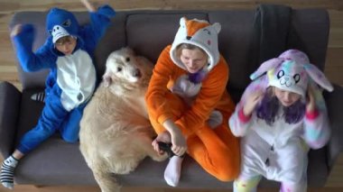 Kigurumi 'deki mutlu aile evdeki oturma odasındaki TV' de oyun konsolu oynuyor.