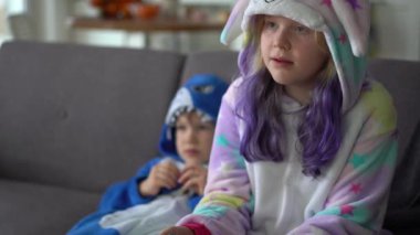 Kigurumi 'deki mutlu aile evdeki oturma odasında TV' de oyun konsolu oynuyor.