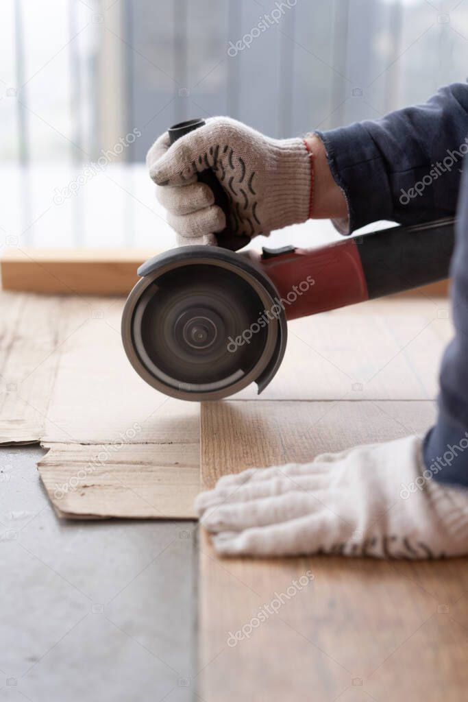 repair and decoration. a man cuts ceramic tiles with a grinder.
