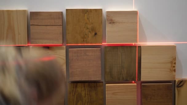 Original modern repair in a loft style. woman decorates a wall in an apartment with wooden pieces — Stock Footage Original modern repair in a loft style. woman decorates a wall in an apartment with wooden pieces Royalty Free Stock Footage