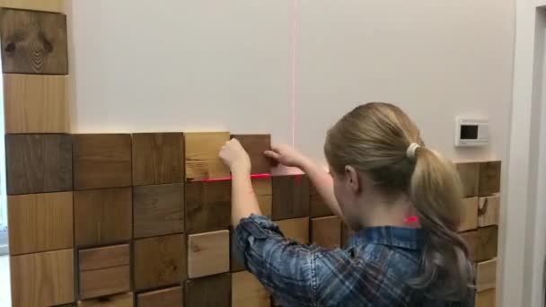 Reparación moderna original en un estilo loft. mujer decora una pared en un apartamento con piezas de madera — Vídeos de Stock