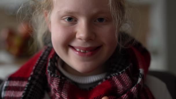 Portrét nemocného dítěte v šále a kostkované s šálkem horkého čaje na pohovce v bytě — Stock video