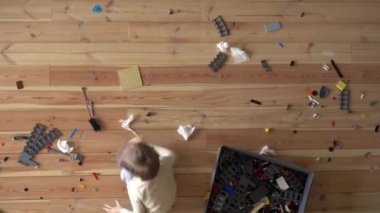 Ev temizliği. Anne ve çocuk evdeki dağınıklığı temizliyor, zaman ayarlı, yukarıdan görünüyor.