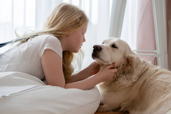 Cuidado y amor por las mascotas. adolescente chica en el hogar abrazos con un golden retriever grande perro —  Fotos de Stock