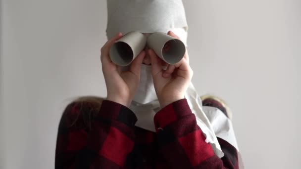 Смішне відео - карантин через епідемію коронавірусу. дівчина в масці з туалетного паперу позує на сірому фоні . — стокове відео
