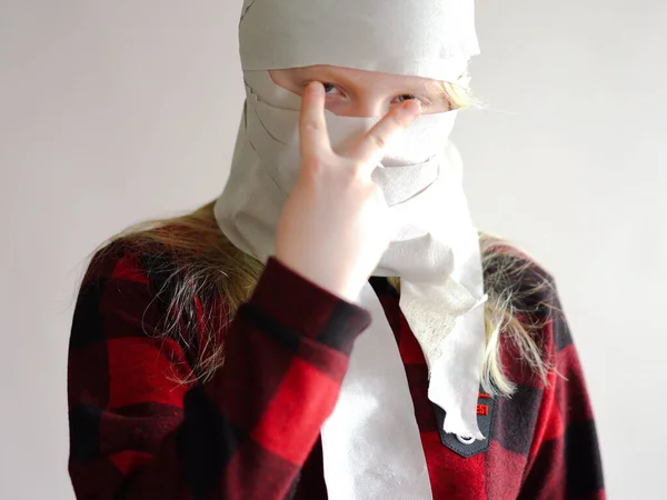 Смешное фото - помещено в карантин из-за эпидемии коронавируса. девушка в маске из туалетной бумаги позирует на сером фоне . — стоковое фото