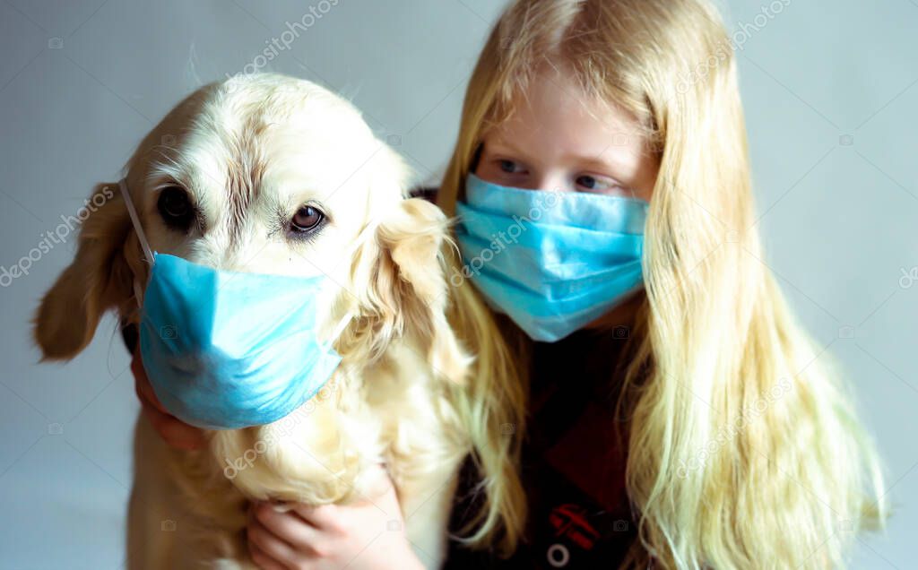 funny photo - quarantined due to an epidemic of coronavirus. portrait of a masked dog and girl on a gray background.