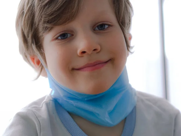 コロナウイルスからの保護。小さな男の子が顔にマスクをつけて. — ストック写真
