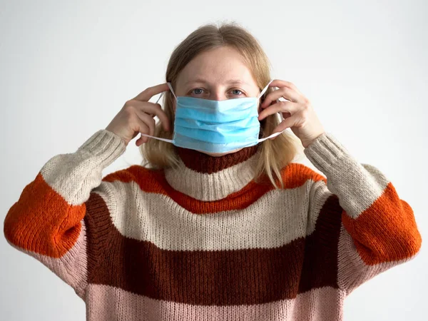 Protección contra el coronavirus. mujer pone una máscara en su cara . —  Fotos de Stock