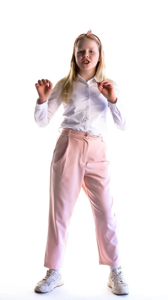 Cheerful schoolgirl girl on a white background in the studio dancing funny dance — Stock Photo, Image