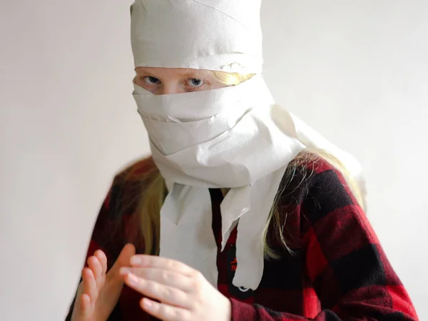 Foto engraçada - quarentena devido a uma epidemia de coronavírus. menina em uma máscara de papel higiênico posando em um fundo cinza . — Fotografia de Stock