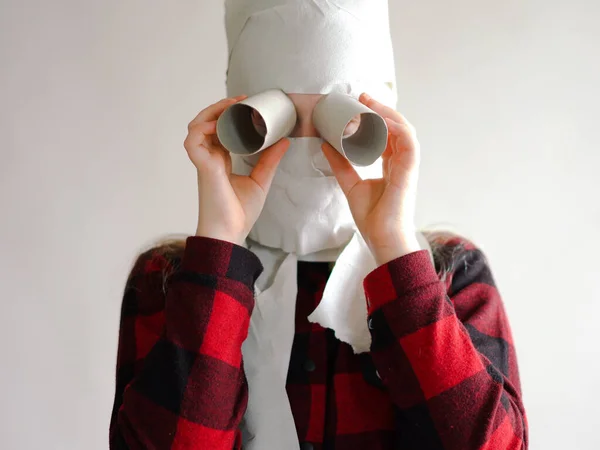 Foto engraçada - quarentena devido a uma epidemia de coronavírus. menina em uma máscara de papel higiênico posando em um fundo cinza . — Fotografia de Stock