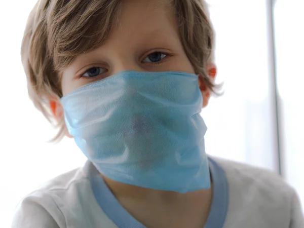 保护人们不感染考罗那韦。小男孩把面具戴在脸上. — 图库照片