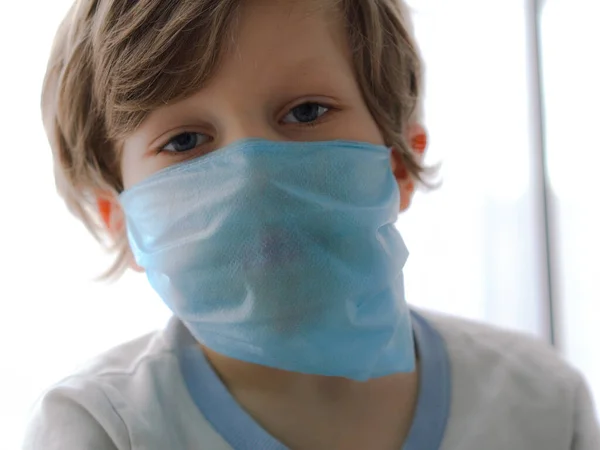 Protección contra el coronavirus. pequeño niño pone una máscara en su cara . —  Fotos de Stock