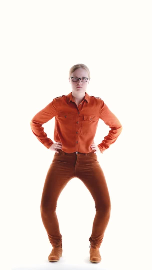 Allvarlig kvinna med glasögon på en vit bakgrund i studio dans dans, vertikal video — Stockvideo