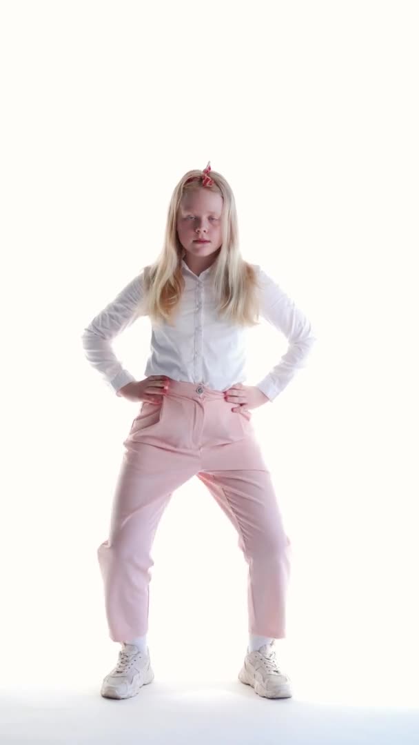 Joyeuse écolière fille sur un fond blanc dans le studio de danse drôle de danse, vidéo verticale — Video