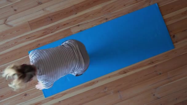Stanna hemma. maskerad kvinna som gör yoga i vardagsrummet under karantän, tiden förfaller. — Stockvideo