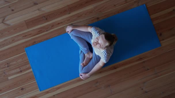 Quédate en casa. mujer haciendo yoga en la sala de estar durante la cuarentena, ejercicios de entrenamiento del cuello — Vídeo de stock