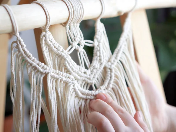 Zuhause bleiben. Arbeit während der Quarantäne - ein Mädchen im Wohnzimmer Wandmalerei Weben der Seile in Makrammatechnik — Stockfoto