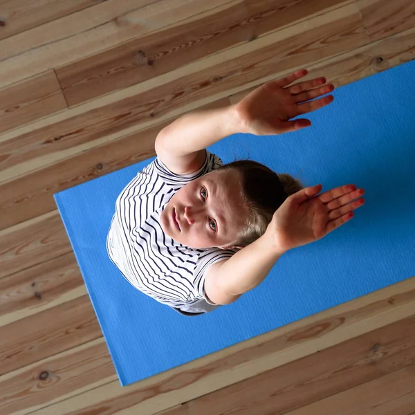 Quédate en casa. mujer haciendo yoga en la sala de estar durante la cuarentena, ejercicios de entrenamiento del cuello — Foto de Stock