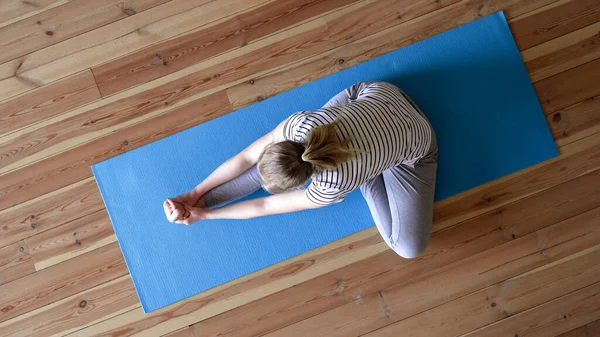 Quédate en casa. mujer haciendo yoga en la sala de estar durante la cuarentena, ejercicios de entrenamiento del cuello — Foto de Stock