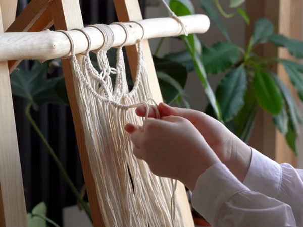 Stay at home. work during the quarantine - a girl in the living room mural weaving of the ropes in the macrame technique — Stock Photo, Image