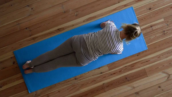 Zostań w domu. kobieta robi jogę w salonie podczas kwarantanny, ćwiczenia na szyi — Zdjęcie stockowe
